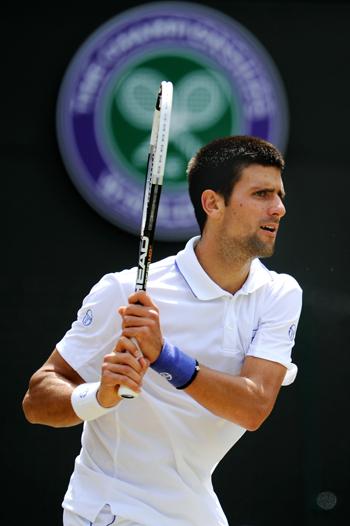 Novak Djokovic of Serbia returns a shot during his quarterfinal round match against Bernard Tomic of Australia on Day Nine of the Wimbledon Championships