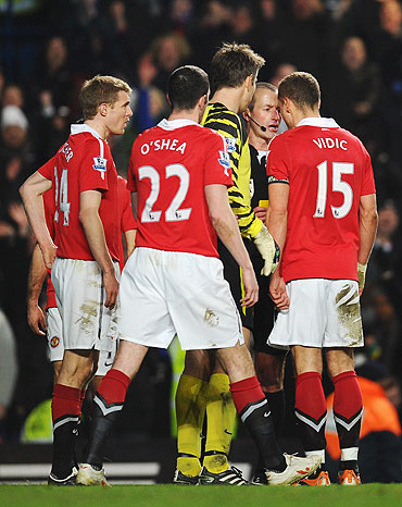 Nemanja Vidic of Manchester United goes head to head with referee Martin Atkinson after being shown the red card