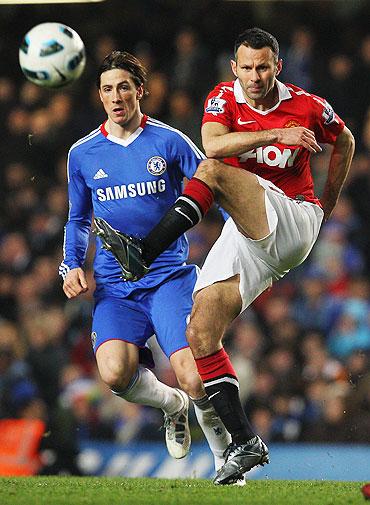 Ryan Giggs of passes as Fernando Torres looks on