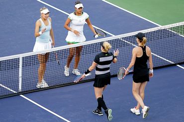 Sania and Elena are congratulated at the net by Bethanie Mattek-Sands and Meghann Shaughnessy