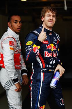 Vettel celebrates after taking pole in Melbourne. In the background is Hamilton
