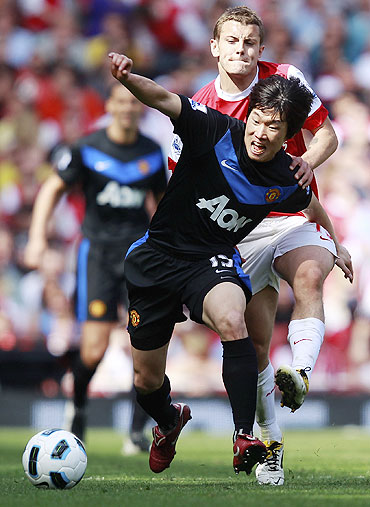 Manchester United's Park Ji-sung (left) wins the ball over Arsenal's Jack Wilshere