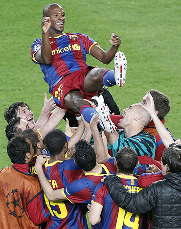 Barcelona's Eric Abidal (top) is lifted by teammates as they celebrate victory over Real Madrid