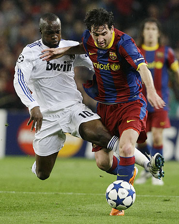 Real Madrid's Lassana Diarra (left) battles for possession with Barcelona's Lionel Messi