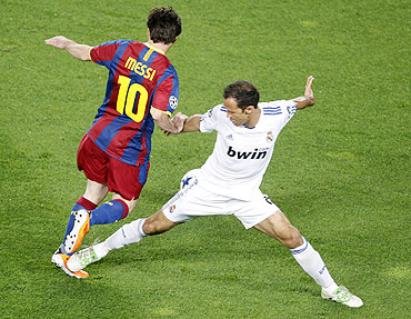 Real Madrid's Ricardo Carvalho fouls Barcelona's Lionel Messi (left)