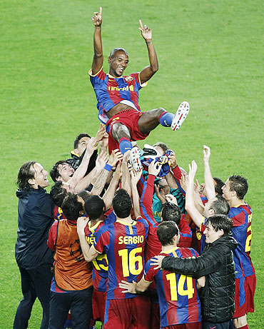 Barcelona's players celebrate with team-mate Eric Abidal (top)