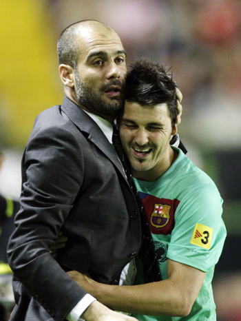 Barcelona's coach Pep Guardiola (L) embraces David Villa after winning the Spanish league in Valencia