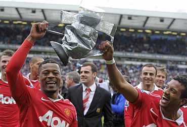 Nani and Patrice Evra with the dummy trophy after winning against Blackburn