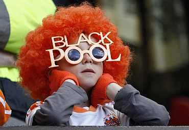 A young Blackpool supporter watches from the stand during their English Premier League soccer match