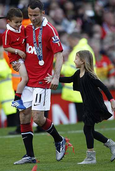 Manchester United's Giggs holds his children Zach and Libby