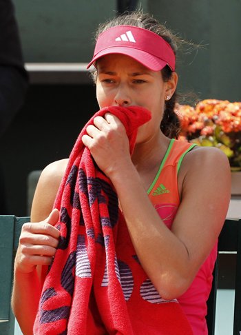 Ana Ivanovic wipes her face after losing