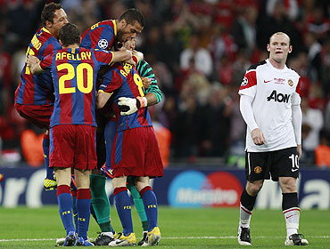 Manchester United's Wayne Rooney (right) walks past as Barcelona's players celebrate their Champions League final victory
