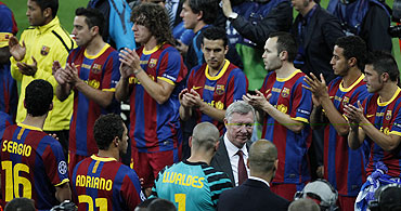 Barcelona's players applaud as Manchester United's manager Alex Ferguson walks by after their Champions League final