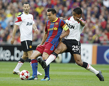 Manchester United's Antonio Valencia (right) and Barcelona's Xavi vie for possession