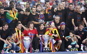Barcelona's team pose with the Champions League and La Liga trophies after winning their Champions League final against Manchester United
