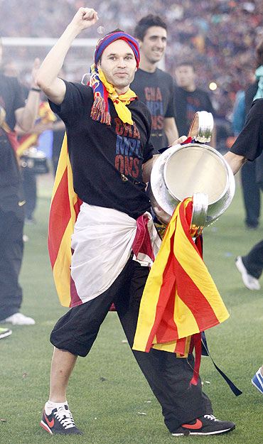 Barcelona's player Andres Iniesta holds the Champions League trophy at Camp Nou stadium in Barcelona on Sunday