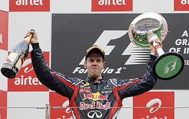 Red Bull's Sebastian Vettel celebrates on podium after winning the Indian GP