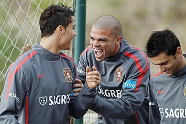 Portugal's Pepe (centre) accompanied by Helder Postiga (right) joke with Cristiano Ronaldo before their training session in Obidos