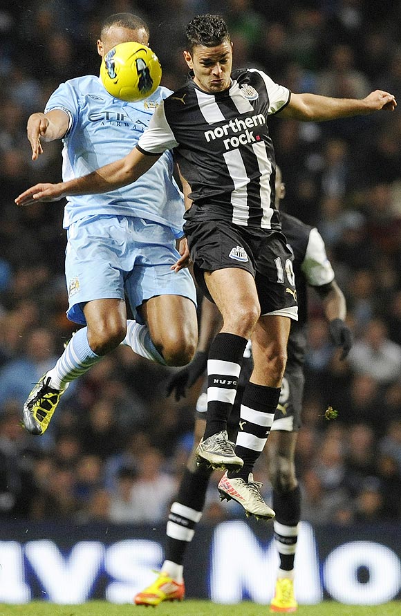Manchester City's Vincent Kompany (left) challenges Newcastle United's Hatem Ben Arfa