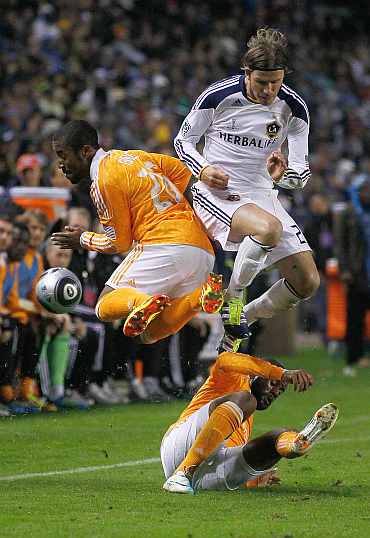 Corey Ashe of the Houston Dynamo collides with David Beckham of the Los Angeles Galaxy