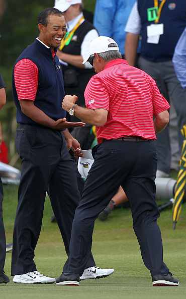Tiger Woods of the US Team celebrates with U.S. Team captain Fred Couples after winning his match