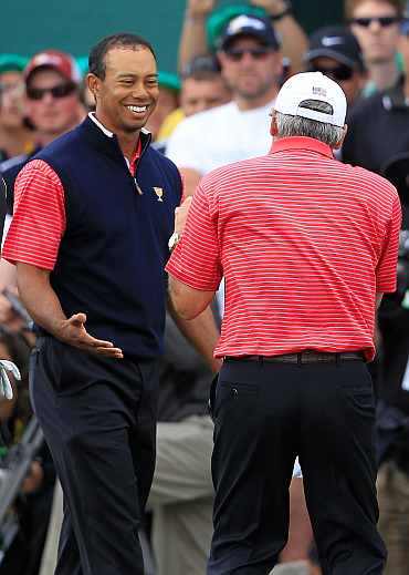 Tiger Woods of the U.S. Team celebrates with U.S. Team captain Fred Couples after winning his match