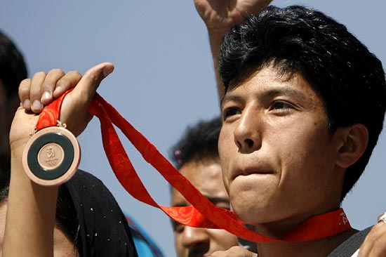 Rohullah Nikpai holds up the bronze medal he won at the 2008 Olympic Games