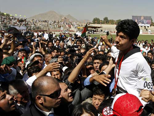 Rohullah Nikpai is carried by the crowd during a procession for his homecoming in Kabul from the Beijing 2008 Olympic Games