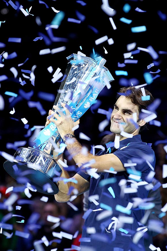 Roger Federer celebrates with the trophy after winning the World Tour finals on Sunday