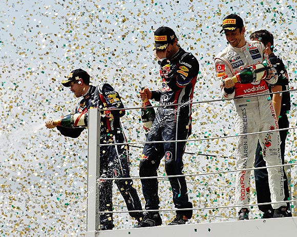 Red Bull's Mark Webber (centre) celebrates on the podium with teammate Sebastian Vettel and third placed Jenson Button (right) of McLaren