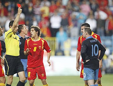 Referee Wolfgang Stark (left) sends off England's Wayne Rooney (right) during their Euro 2012 Group G qualifying match against Montenegro