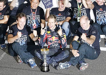 Red Bull's Sebastian Vettel (centre) celebrates with crew members after winning the championship title following the Japan GP on Sunday
