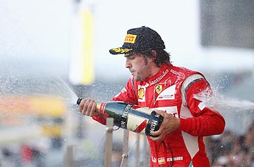 Ferrari's Fernando Alonso celebrates with champagne after the Japan GP