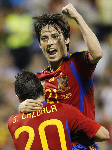 Spain's David Silva celebrates with teammate Santi Cazorla after scoring against Scotland during their Euro 2012 qualifying Group I soccer match at the Perez Rico Stadium in Alicante