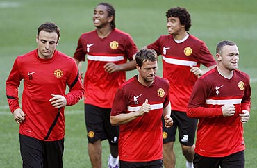 Manchester United players run to warm up at the start of their training session