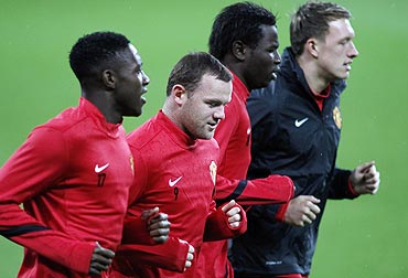Manchester United's Danny Welbeck (left), Wayne Rooney (2nd from left), Mame Diouf (2nd from right) and Phil Jones warm up during a training session on Tuesday