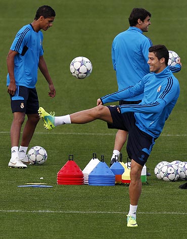 Real Madrid's Cristiano Ronaldo, Raphael Varane (left) and Kaka (right) go through the motions during their team's training session