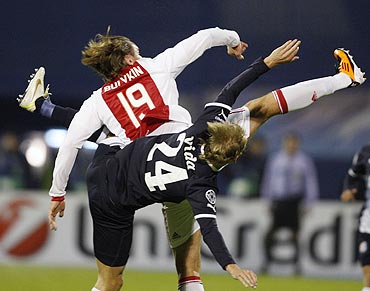 Dmitri Bulykin (left) of Ajax Amsterdam challenges Domagoj Vida of Dinamo Zagreb