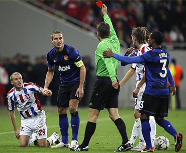 Nemanja Vidic (2nd from left) is booked by the referee