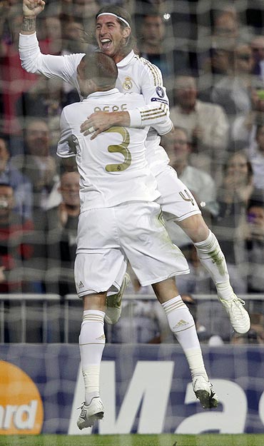 Real Madrid's Sergio Ramos celebrates with teammate Pepe after scoring against Olympique Lyon