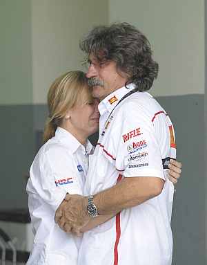Paolo (R), the father of Marco Simoncelli of Italy, is consoled inside the pit