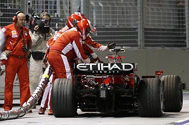 Ferrari pit crew gesture while attempting to remove a fuel hose from the car of Ferrari Formula One driver Felipe Massa