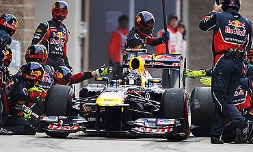 Red Bull's crew members change the tyres during a pitstop by Sebastian Vettel
