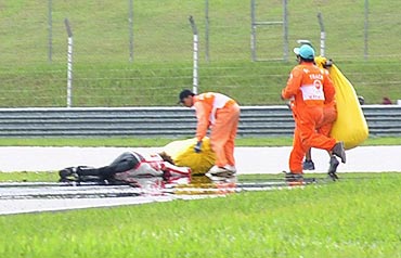 Honda MotoGP's Marco Simoncelli of Italy lies on the ground after a crash during the Malaysian Grand Prix