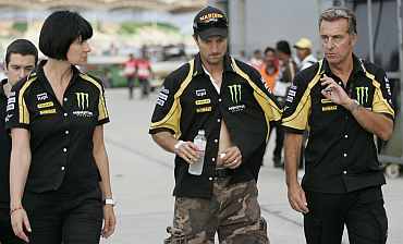 Yamaha's Colin Edwards listens to his crew as he leaves the medical centre after a crash with Honda MotoGP rider Marco Simoncelli