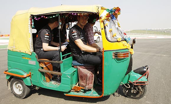 McLaren's Jenson Button drives an auto rickshaw at the Buddh International Circuit in Greater Noida on Thursday