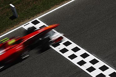 Felipe Massa of Ferrari drives past the DRS zone indication board