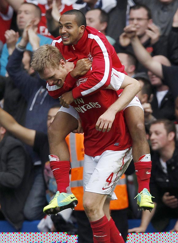Arsenal's Theo Walcott (top) and Per Mertesacker celebrate after beating Chelsea
