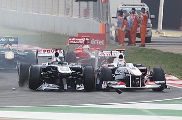 Rubens Barrichello (left) of Brazil and Williams loses his front wing in a collision with Kamui Kobayashi (right) of Japan and Sauber F1