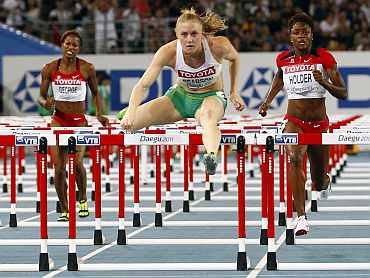 Sally Pearson of Australia clears a hurdle next to Holder of Canada and George of Canada to win the women's 100 metres hurdles